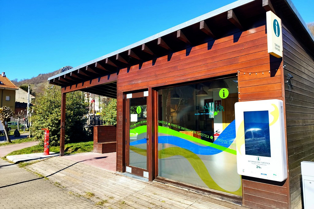 Centro de información turística con fachada de madera y ventanas grandes en un día soleado