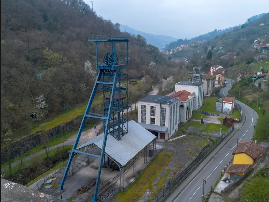 Estructura industrial de minería con un elevador en un paisaje montañoso y carretera cercana