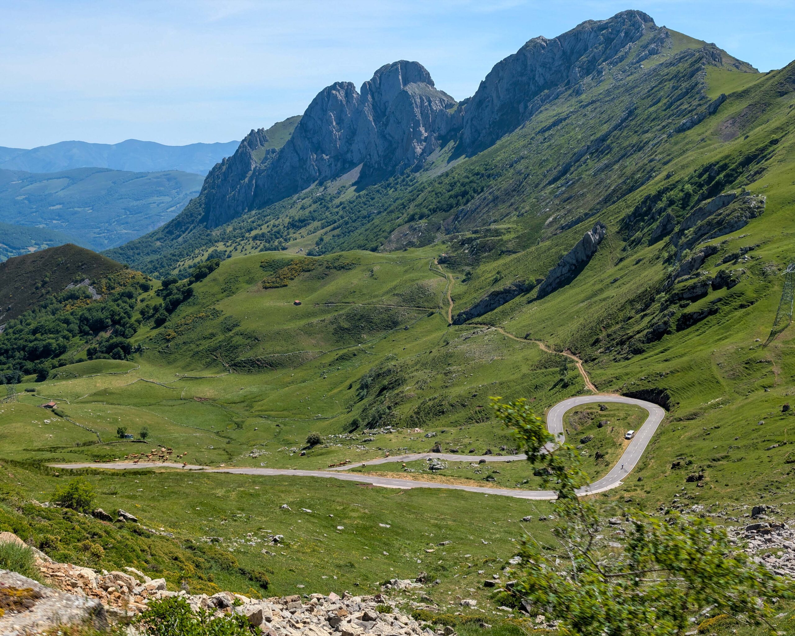 Paisaje montañoso con colinas verdes y una carretera serpenteante en el valle