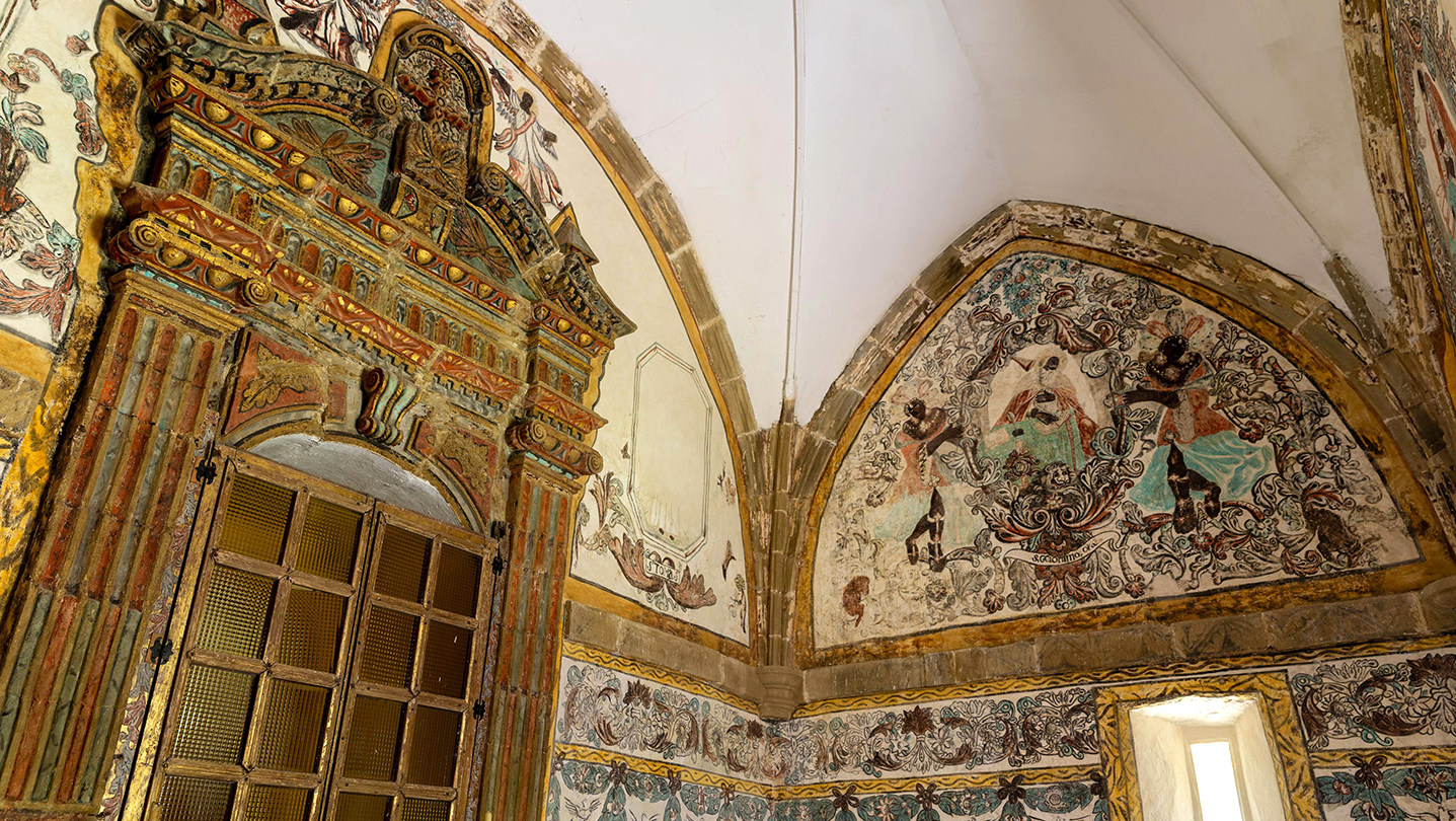 Detalles arquitectónicos y murales coloridos en el interior de una habitación histórica