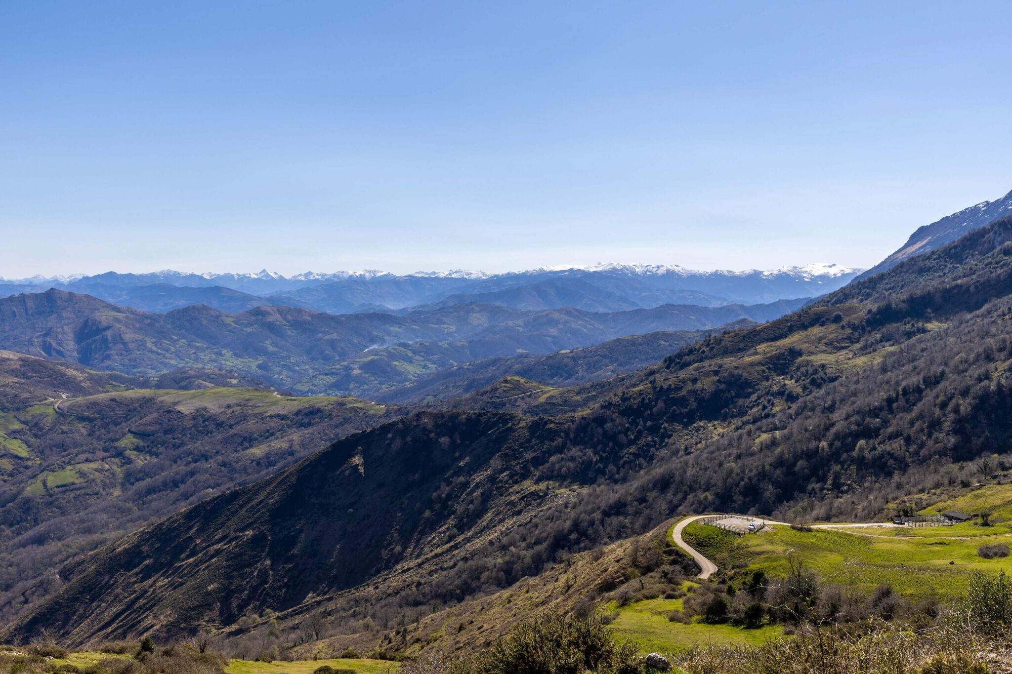 Vista panorámica de montañas y valles verdes bajo un cielo despejado