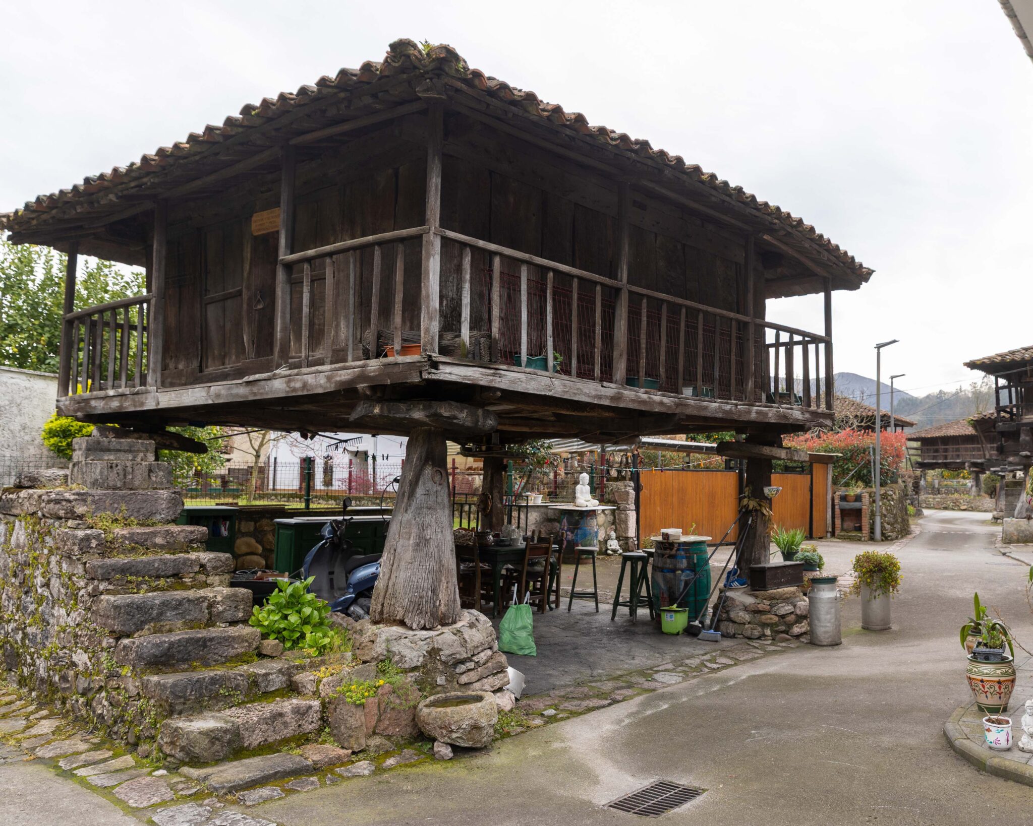 Casa de madera elevada sobre pilares, con escaleras de piedra y un entorno rural