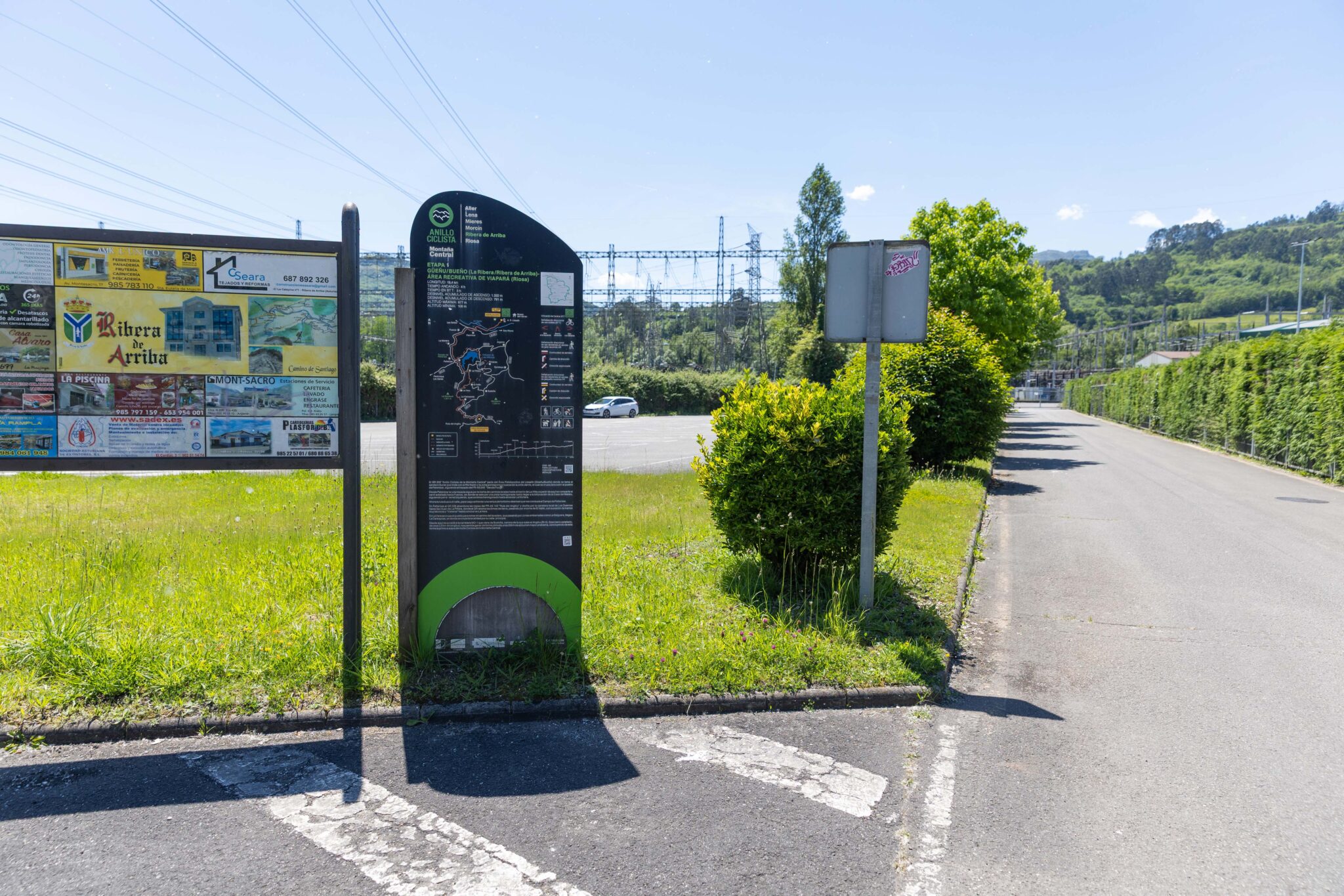 Panel informativo en una zona rural, con un camino y vegetación al fondo