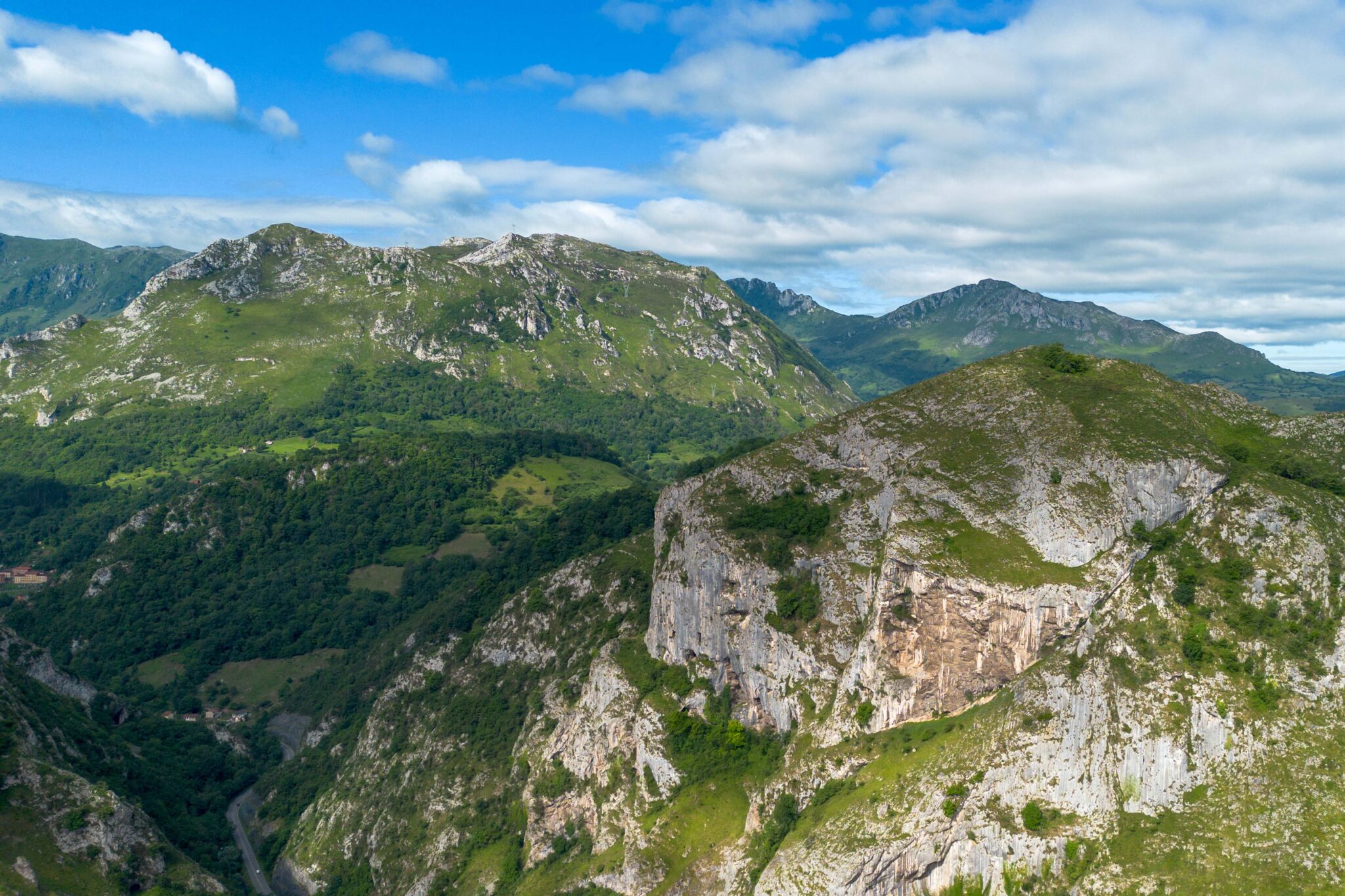 Paisaje montañoso con colinas verdes y nubes en un cielo azul