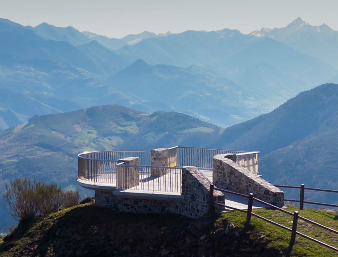 Mirador de piedra con barandilla en un paisaje montañoso y vistas panorámicas