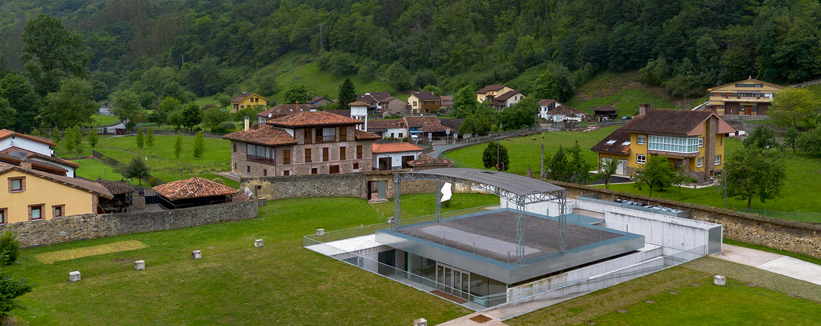 Vista panorámica de un paisaje rural con casas y un edificio moderno en el centro